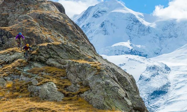 Singletrack Switzerland Singletrack Switzerland: Carston Oliver guida Brice Shirbach sugli epici singletrack di Zermatt con il ghiacciaio Gorner, al confine italiano, sullo sfondo. Foto: Grant Gunderson