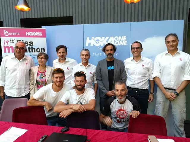 Alcuni esponenti di AD 1063, società organizzatrice dell'evento pisano in compagnia di Alessio Ranallo, in grigio, responsabile di Hoka One One e alcuni atleti Hoka accosciati