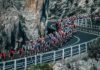 milano-sanremo foto in movimento del gruppo su strada a picco sul mare