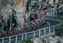 milano-sanremo foto in movimento del gruppo su strada a picco sul mare