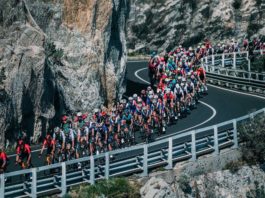 milano-sanremo foto in movimento del gruppo su strada a picco sul mare