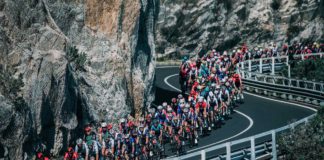 milano-sanremo foto in movimento del gruppo su strada a picco sul mare