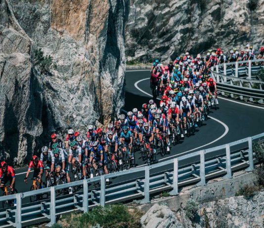 milano-sanremo foto in movimento del gruppo su strada a picco sul mare